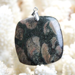 Peut inclure: Un pendentif carré en pierre verte et rose avec une bélière en argent. La pierre présente un motif tourbillonnant de vert, de rose et de noir.