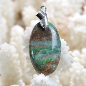 May include: A green and brown oval pendant with a silver bail. The pendant is made of a natural stone with a layered pattern.