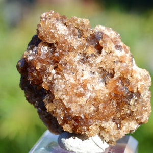 Könnte beinhalten: Ein Cluster aus braunen und klaren Quarzkristallen mit einer rauen, strukturierten Oberfläche. Die Kristalle sind in einer natürlichen Formation zusammengefügt.