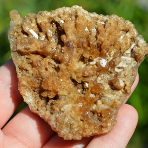 Könnte beinhalten: Ein Cluster aus braunen und weißen Kristallen in einer rauen, natürlichen Formation. Die Kristalle sind in einer dichten, unregelmäßigen Form zusammengefügt.
