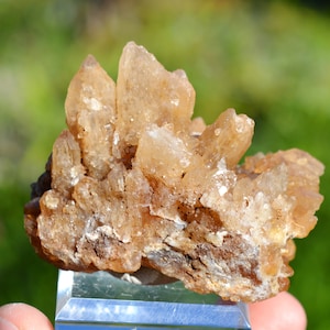 Könnte beinhalten: Ein Cluster aus hellbraunen Quarzkristallen mit einer rauen, natürlichen Textur. Die Kristalle sind in einer zufälligen Formation zusammengefügt und bilden eine einzigartige und interessante Darstellung.