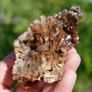 Könnte beinhalten: Ein Cluster aus braunen Calcitkristallen mit einer rauen, natürlichen Textur. Die Kristalle sind in einer dichten Formation zusammengefügt und bilden eine einzigartige und interessante Darstellung.