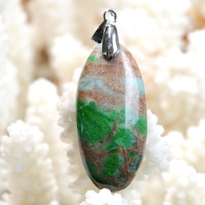 May include: A green and brown oval shaped pendant with a silver bail. The pendant is made of a natural stone with a unique pattern.
