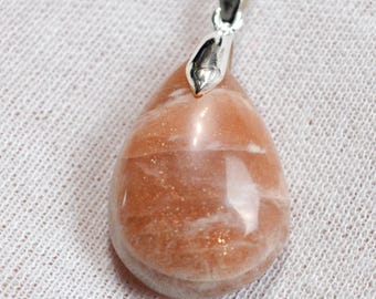May include: A teardrop-shaped sunstone pendant with a silver bail. The sunstone is a light orange color with a shimmery, iridescent finish.