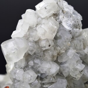 Puede incluir: Un grupo de cristales transparentes, blancos y transl&uacute;cidos con una superficie rugosa y texturizada. Los cristales est&aacute;n agrupados en un patr&oacute;n aleatorio y org&aacute;nico.