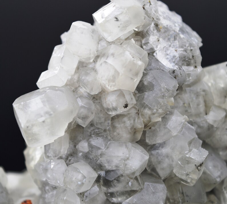 Puede incluir: Un grupo de cristales transparentes, blancos y transl&uacute;cidos con una superficie rugosa y texturizada. Los cristales est&aacute;n agrupados en un patr&oacute;n aleatorio y org&aacute;nico.