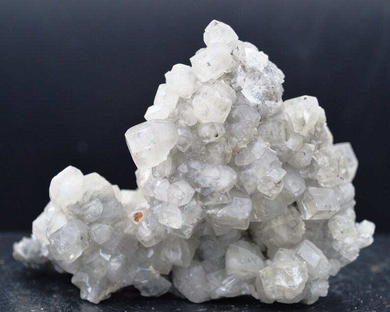 Puede incluir: Un grupo de cristales de calcita blancos con una superficie rugosa y texturizada. Los cristales est&aacute;n agrupados en una formaci&oacute;n natural, creando una exhibici&oacute;n &uacute;nica e interesante.