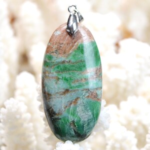 May include: A green and brown oval-shaped pendant with a silver bail. The pendant is made of a natural stone with a unique pattern.