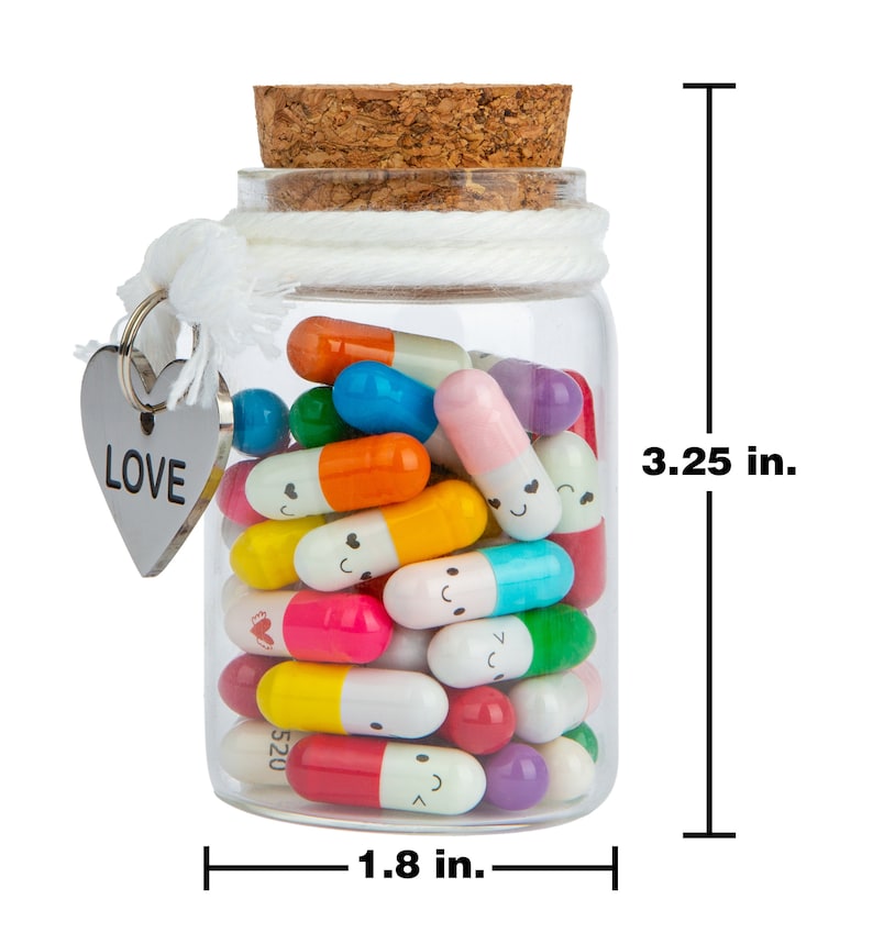 Pode incluir: Um frasco de vidro cheio de c&aacute;psulas coloridas com carinhas sorridentes, cada uma contendo uma nota de amor. O frasco tem uma tampa de corti&ccedil;a e um amuleto em forma de cora&ccedil;&atilde;o com a palavra "LOVE" nele. O frasco mede 3,25 polegadas de altura e 1,8 polegadas de largura.