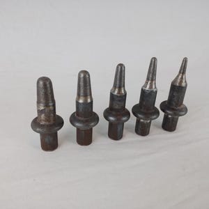 Op de afbeelding: Set van zes metalen nagelkoppen in verschillende vormen en maten. De nagelkoppen zijn allemaal zilverkleurig en hebben een licht verweerde afwerking.