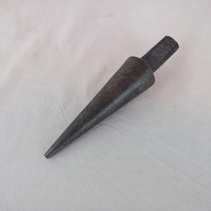 May include: A metal cone-shaped tool with a flat handle. The tool is gray and has a slightly rusted appearance.