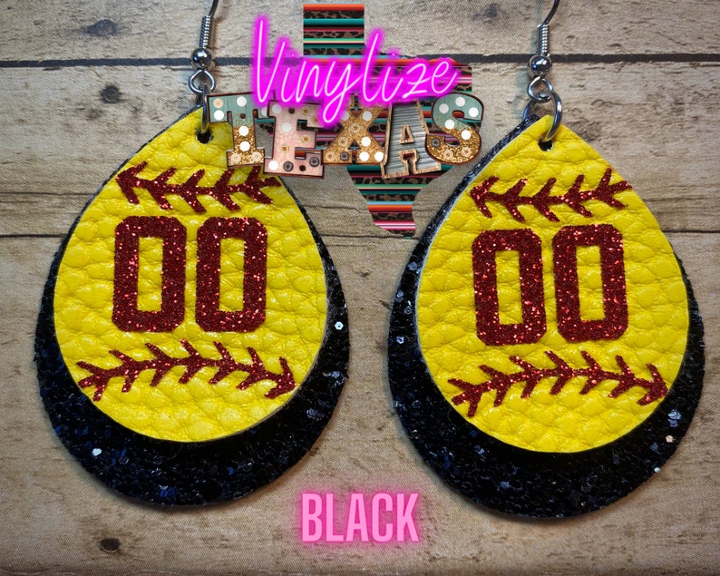 K&ouml;nnte beinhalten: Ein Paar schwarze und gelbe Softball-Ohrringe mit roten Glitzerzahlen 00. Die Ohrringe sind aus Leder und haben eine schwarze Glitzer-R&uuml;ckseite.