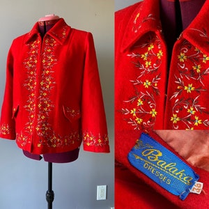 May include: Red wool jacket with yellow floral embroidery and a zip closure. The jacket has a label that reads "Balboa Dresses 92".