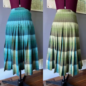 Puede incluir: Una falda midi plisada con un patrón de cuadros en degradado. El lado izquierdo muestra una paleta de colores azul verdoso, turquesa y verde claro, mientras que el lado derecho cambia a tonos verde oliva, lima y amarillo suave en tela tejida.