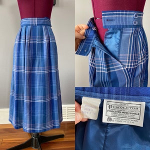 May include: A blue and white plaid skirt with a pink stripe. The skirt is made of wool and has a label that reads "Miss Pendleton Pendleton Woolen Mills Portland, Oregon 100% Virgin Wool Pure Virgin Wool Made in U.S.A."