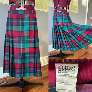 May include: A red, green and blue plaid kilt skirt with a yellow stripe. The skirt is pleated and has a wrap-around closure. The label reads "D'Allaird's Made in/Fabrique au Canada CA 00434 Style/Modele Size/Taille 70% Polyester 30% Rayon/Rayonne Care Instruction on Reverse Side/Voir au Verso pour Entre"