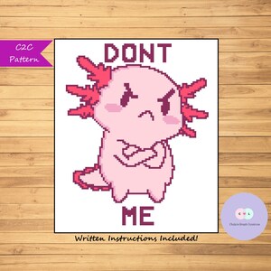 May include: C2C crochet pattern featuring a pink axolotl with red gills, crossed arms, and the text "DONT ME". Written instructions are included.
