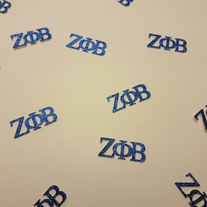 May include: Blue glitter confetti with the letters "ZOB" printed on each piece.