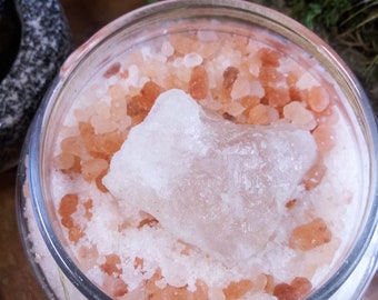 May include: A glass jar filled with pink Himalayan salt and a large, clear crystal on top. The jar is tied with twine.