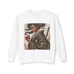 May include: White sweatshirt featuring a graphic of a woman in a black and gold kimono holding a red apple. A sword is visible behind her. The text "Galatians 5:22-23" is also present.