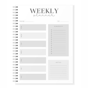 May include: A white weekly planner with a gray background and a black spiral binding. The planner has sections for each day of the week, a reminder section, and a notes section. The text "WEEKLY planner" is at the top of the page.