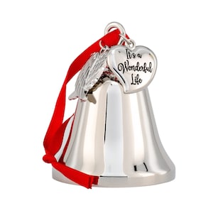 May include: A silver bell ornament with a red ribbon. The bell has a heart-shaped charm that reads "It's a Wonderful Life." A small silver wing charm is also attached. This holiday decoration is perfect for Christmas.