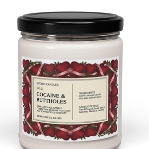 May include: A white ceramic mug with a black handle and the text "But First, Coffee" in a black, handwritten-style font. The mug is on a white surface.