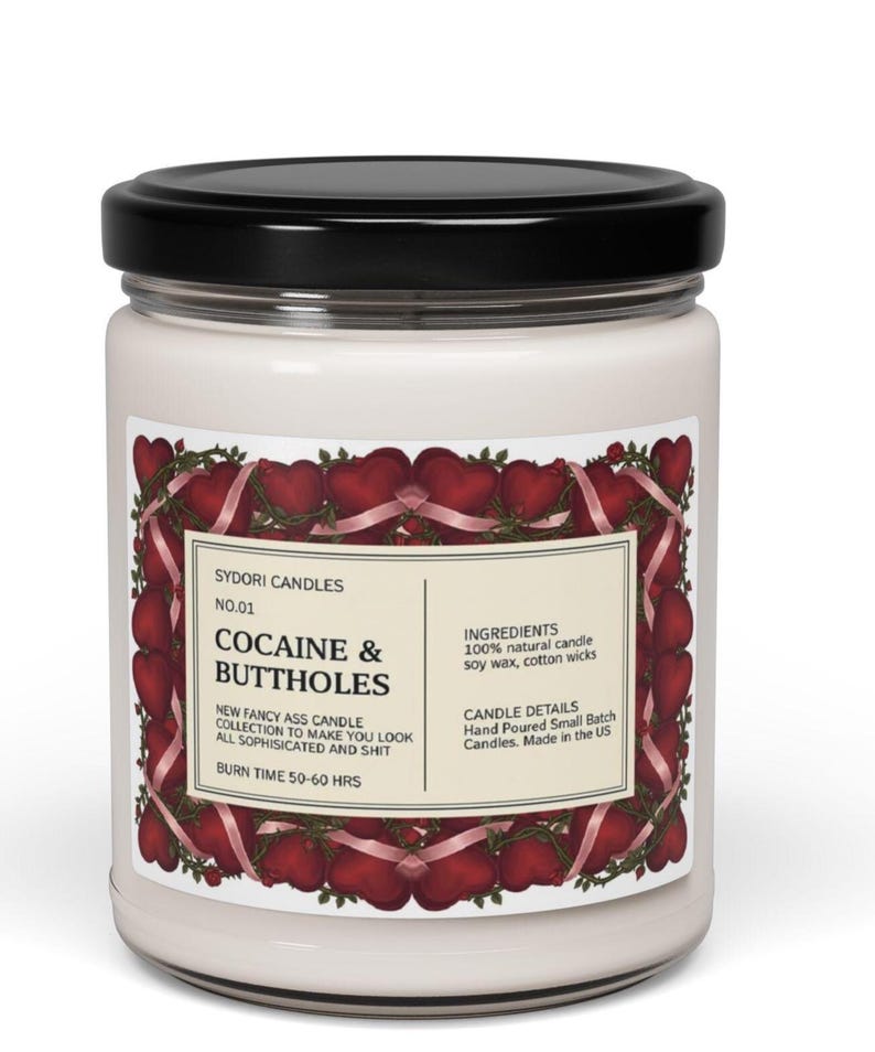 May include: A white ceramic mug with a black handle and the text "But First, Coffee" in a black, handwritten-style font. The mug is on a white surface.