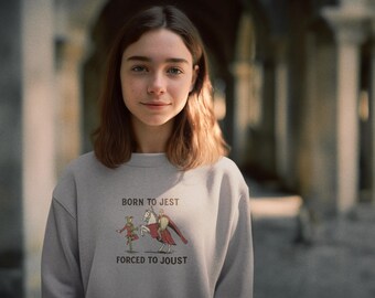Könnte beinhalten: Hellgraues Sweatshirt mit dem Text "BORN TO JEST FORCED TO JOUST" und einer Grafik eines Narren und eines Ritters zu Pferd. Das Sweatshirt ist aus einem weichen Material.