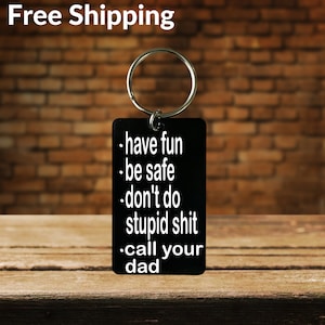 May include: Black rectangular keychain with a silver ring. The keychain has white text that reads: "have fun, be safe, don't do stupid shit, call your dad."