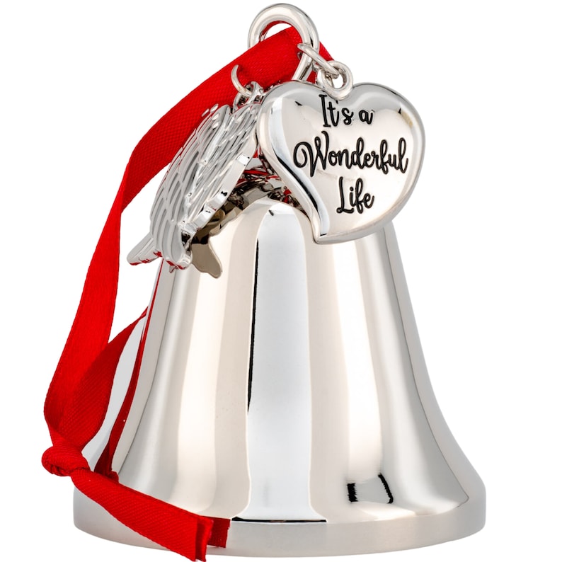 May include: A silver-colored bell ornament with a red ribbon. The ornament has a heart-shaped charm that reads "It's a Wonderful Life." There is also a silver wing charm. The bell is reflective and has a classic shape.