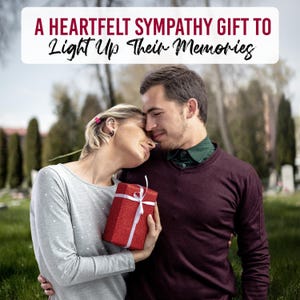 May include: A couple embraces outdoors, with a red gift box tied with a white ribbon. The image includes text that reads, "A Heartfelt Sympathy Gift To Light Up Their Memories."