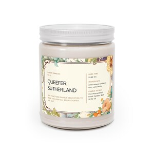 May include: A beige candle jar with a silver lid. The label features a floral design and the text "SIDORI CANDLES", "QUEEFER SUTHERLAND", "NEW FANCY ASS CANDLE COLLECTION TO MAKE YOU LOOK ALL SOPHISTICATED AND SHIT", "BURN TIME 50-60 HRS", "INGREDIENTS 100% NATURAL CANDLE WAX, COTTON WICKS", "CANDLE DETAILS HAND POURED SMALL BATCH CANDLES MADE IN THE US".