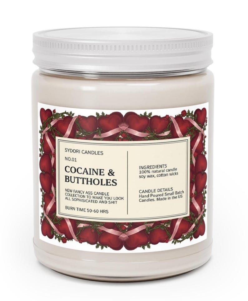 Puede incluir: Una vela en tarro blanco con tapa blanca. La etiqueta dice "COCAINE & BUTTHOLES" con un dise&ntilde;o de coraz&oacute;n y cinta. La etiqueta tambi&eacute;n indica que la vela est&aacute; hecha con cera de soja y mechas de algod&oacute;n, y tiene un tiempo de combusti&oacute;n de 50-60 horas.