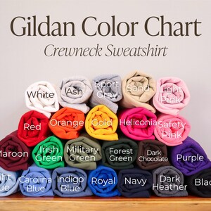 May include: Gildan Color Chart for Crewneck Sweatshirts. The chart shows a variety of colors, including white, ash, sport gray, sand, light pink, red, orange, gold, heliconia, safety pink, maroon, Irish green, military green, forest green, dark chocolate, purple, light blue, Carolina blue, indigo blue, royal blue, navy, dark heather, and black.