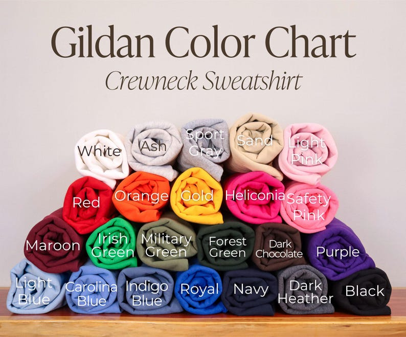 May include: Gildan Color Chart for Crewneck Sweatshirts. The chart shows a variety of colors, including white, ash, sport gray, sand, light pink, red, orange, gold, heliconia, safety pink, maroon, Irish green, military green, forest green, dark chocolate, purple, light blue, Carolina blue, indigo blue, royal blue, navy, dark heather, and black.