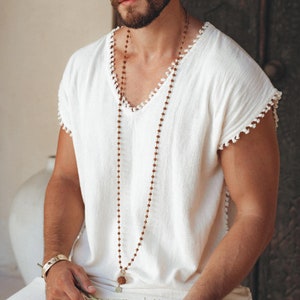 Get the perfect off-white T-shirt with a casual Boho vibe. With the handmade details and knotwork, this is the ideal choice for men's fashion. Make sure to check out the sizes before shopping.