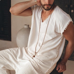 Take your style up a notch with this handmade Boho shirt! Crafted with intricate knotwork, this off-white T-shirt will keep you looking good all summer. Check out the size range and find the perfect fit.