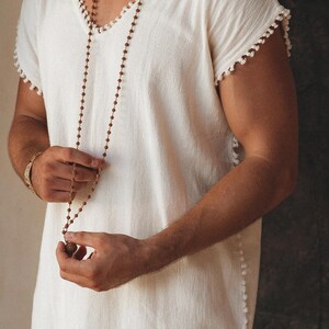 Look your best no matter the occasion with this handmade twist on the classic tank top tee. This off-white T-shirt with a Boho flair will make sure you stand out. Comfortably shop the size range and choose your perfect fit.