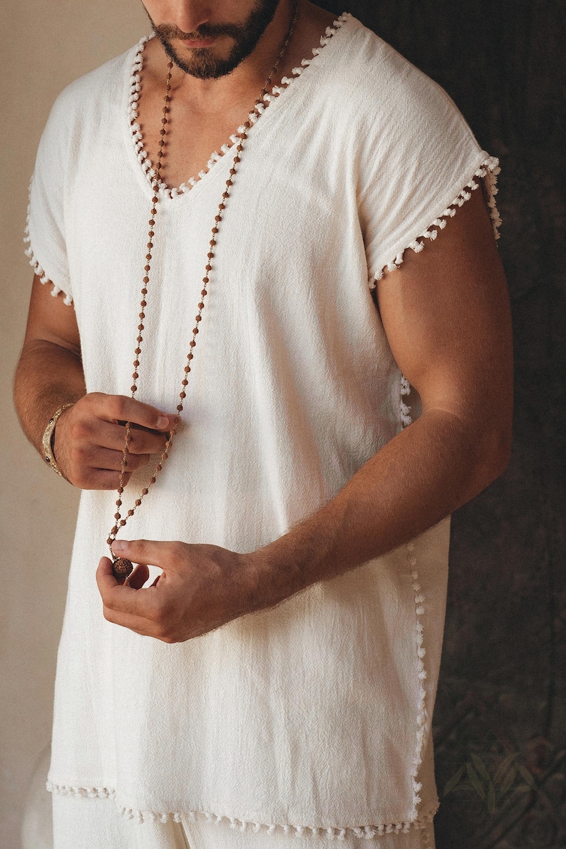 Look your best no matter the occasion with this handmade twist on the classic tank top tee. This off-white T-shirt with a Boho flair will make sure you stand out. Comfortably shop the size range and choose your perfect fit.