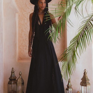 Look divine in this beautiful black dress featuring an empire waist for comfort, low back slit, and handmade macramé details.