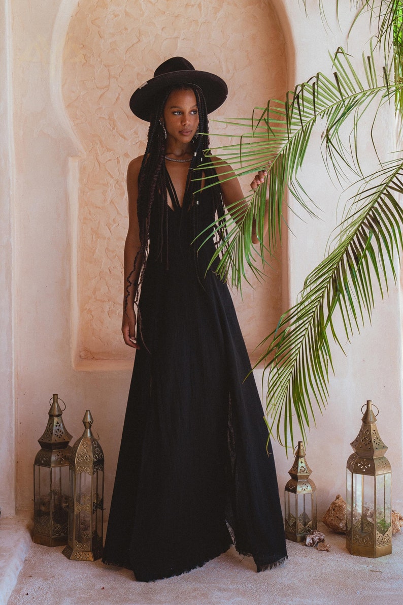 Look divine in this beautiful black dress featuring an empire waist for comfort, low back slit, and handmade macramé details.