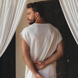 Enjoy a pick-me-up style fix with this off-white T-shirt that features a cool and casual Boho flair. You’ll love the handmade fabric and knotwork details that wrap around your frame. Choose the perfect size from the size range for your desired fit.