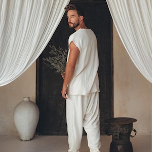 Showcasing handmade craftsmanship, this Boho shirt for men has an off-white T-shirt base with detailed knot work, creating a stunning piece of fashion. Take your look to the next level by selecting the perfect size from the size range options.