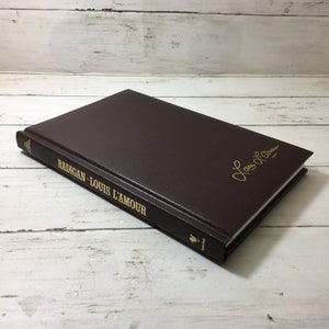 Sold at Auction: LOUIS L'AMOUR LEATHERETTE WESTERN HARDCOVERS