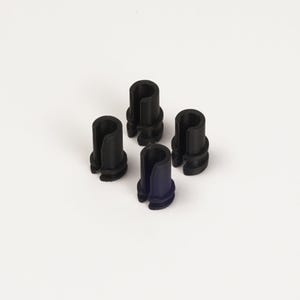 Op de afbeelding: Vier zwarte plastic cilindrische objecten met een verticale sleuf, gerangschikt op een witte achtergrond. Eén object is donkerblauw van kleur. De objecten hebben een geribbelde basis en een holle binnenkant.