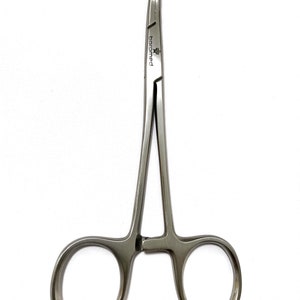 May include: Silver surgical needle holder with a curved tip and a locking mechanism. The needle holder is labeled "baromed".