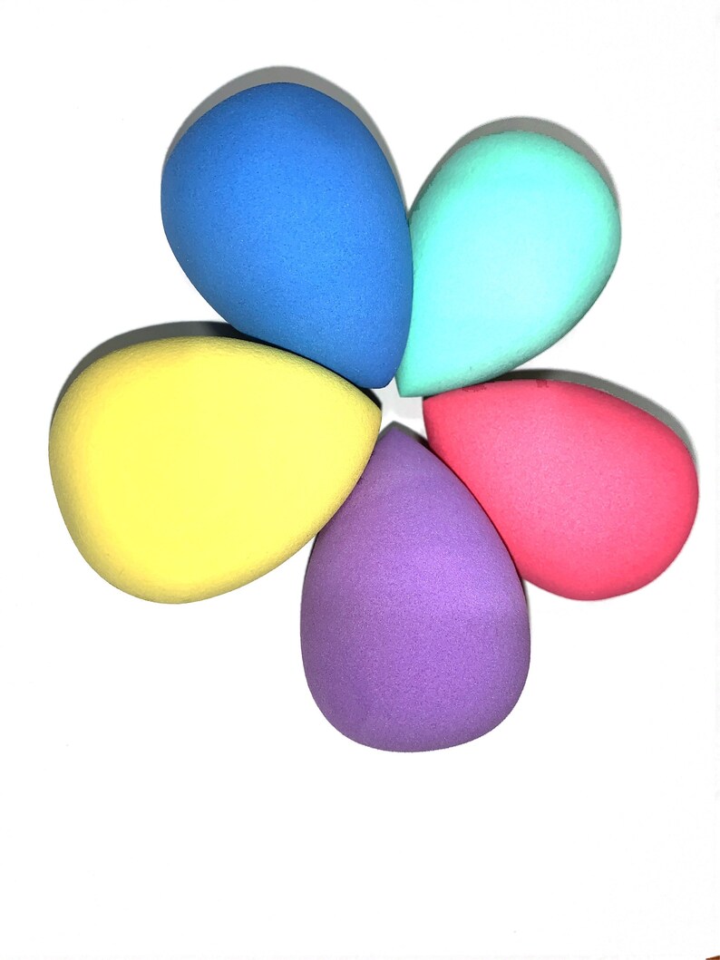 May include: Five teardrop-shaped makeup sponges in different colors: blue, turquoise, yellow, purple, and pink.