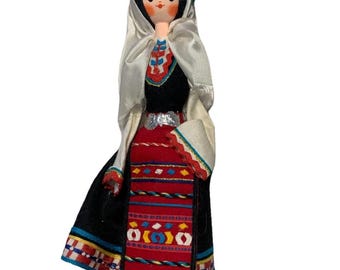 Muñeca folclórica antigua de Europa del Este con mujer vestida con traje tradicional.