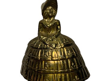 Campana de cena victoriana antigua de latón, estilo sureño, con falda de aros y sombrero.